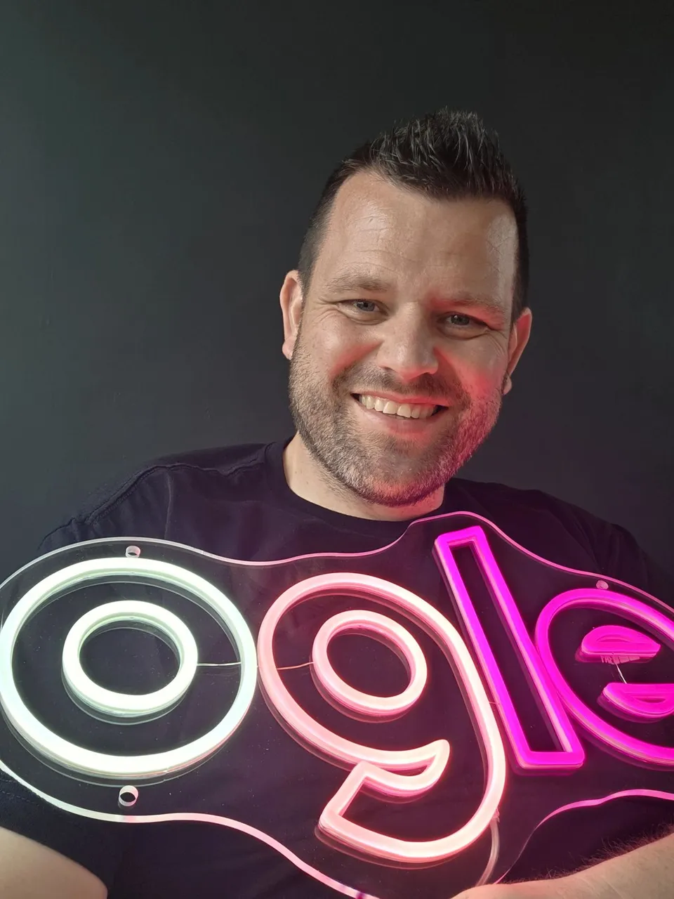 Chris Ogle holding his pink and white neon Ogle sign